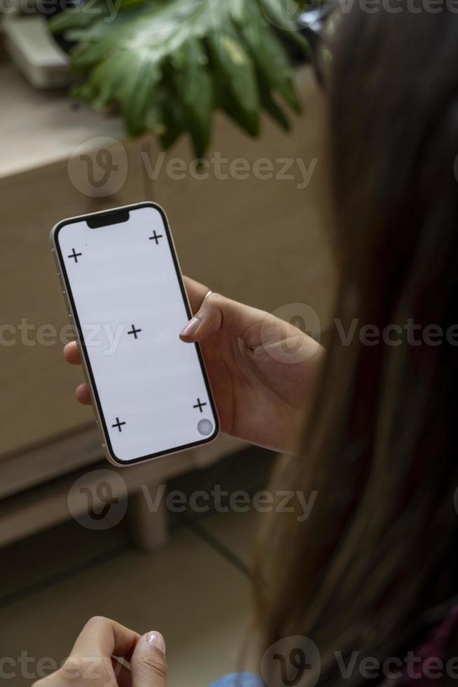 phone with green screen, in a warm home environment, held by a latina woman's hand photo