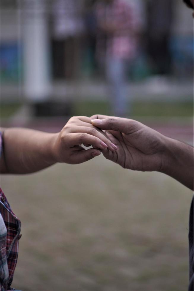 pareja tomados de la mano al aire libre cerca de las manos de la mujer y el hombre foto