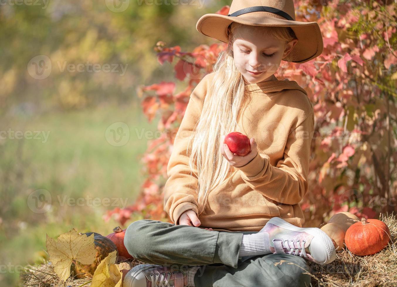 Girl in the hay with pumpkins photo