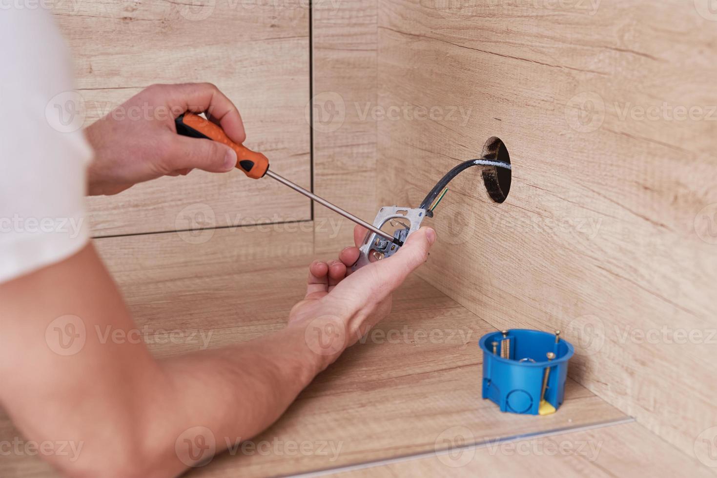 Electrician installing socket plug in the kitchen. Renovation concept photo