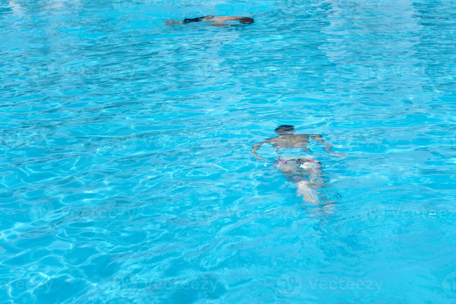 niño con máscara de buceo nadar bajo el agua en la piscina foto