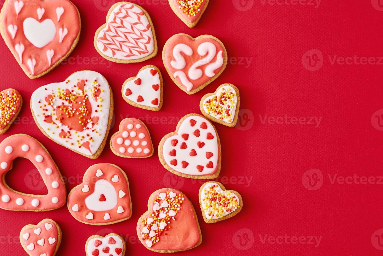 Glazed with icing heart shape cookies on the red backgroundwith copy space. Valentines Day food concept photo