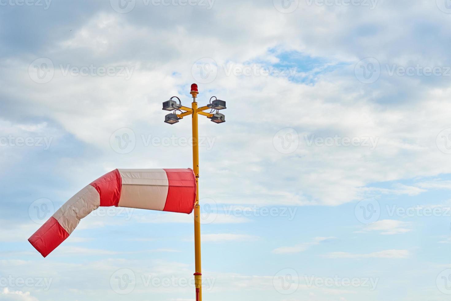 Windsock. Indicator of a blowing wind against cloudy sky photo