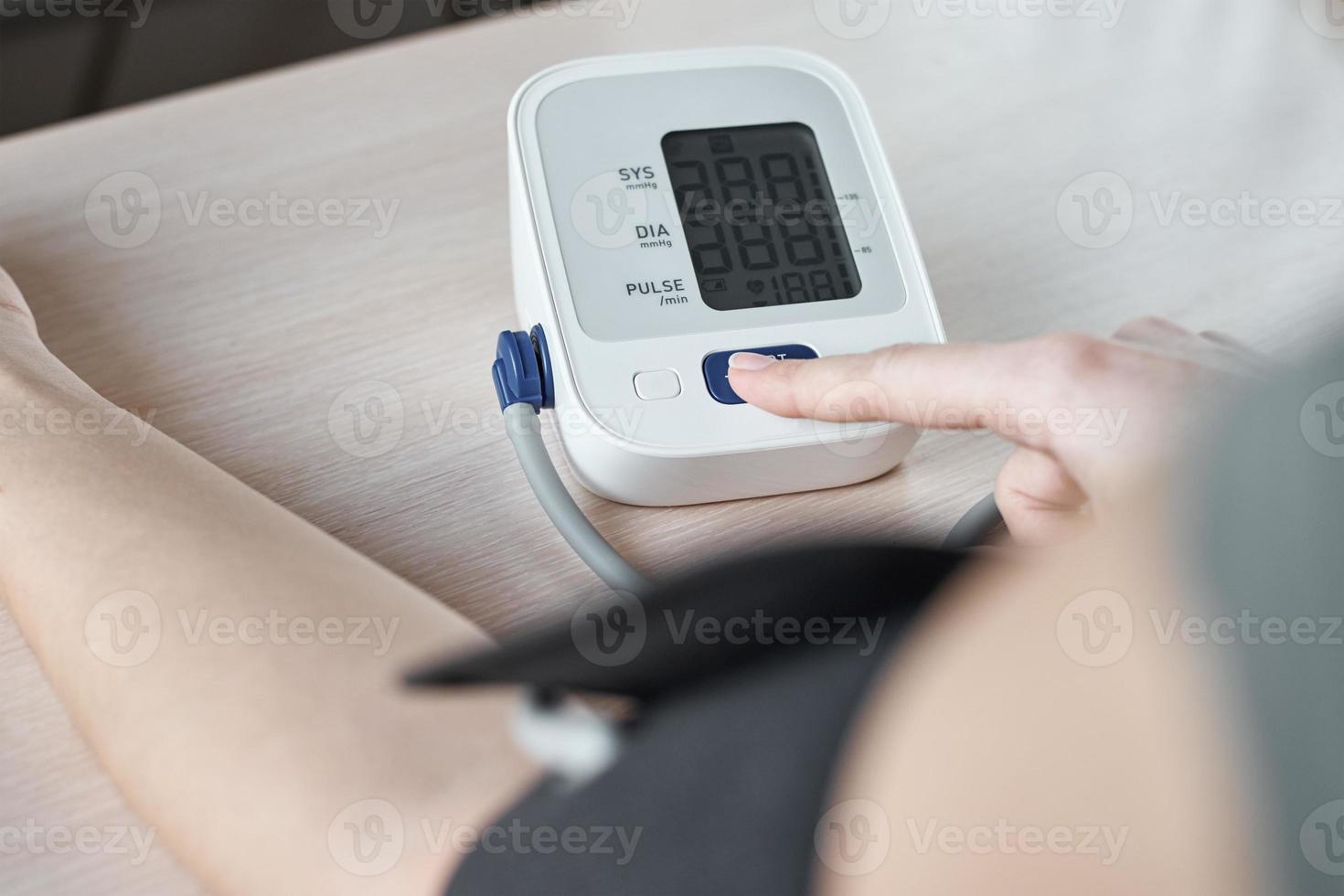 Woman measuring blood pressure with an electric digital tonometer. Healthcare and medicine concept photo