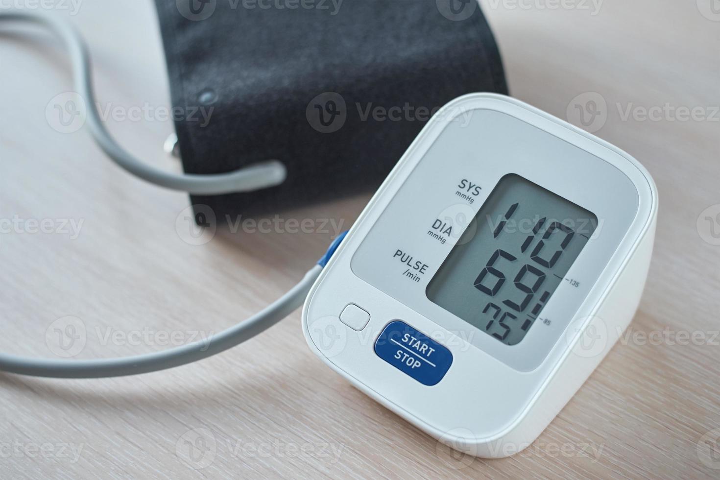 Digital blood pressure monitor on the table, closeup. Helathcare and medical concept photo