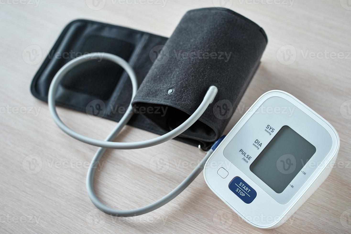 Digital blood pressure monitor on the table, closeup. Helathcare and medical concept photo