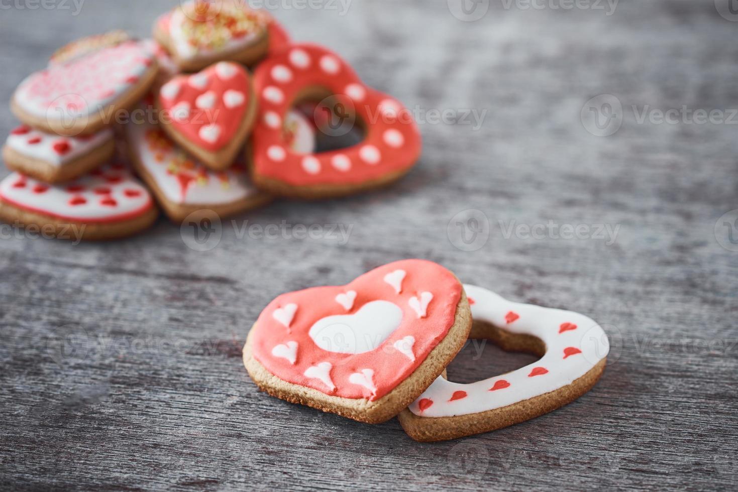 Two heart shape cookies and many decorated cookies on the gray background. Valentines Day concept photo
