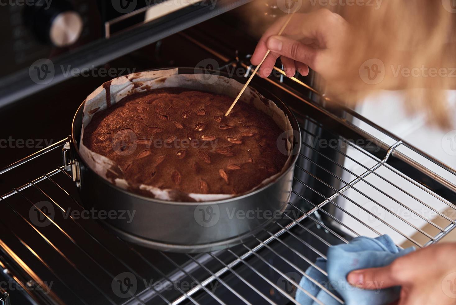 Housewife prepare cake in kitchen. Homemade cake baking in oven photo
