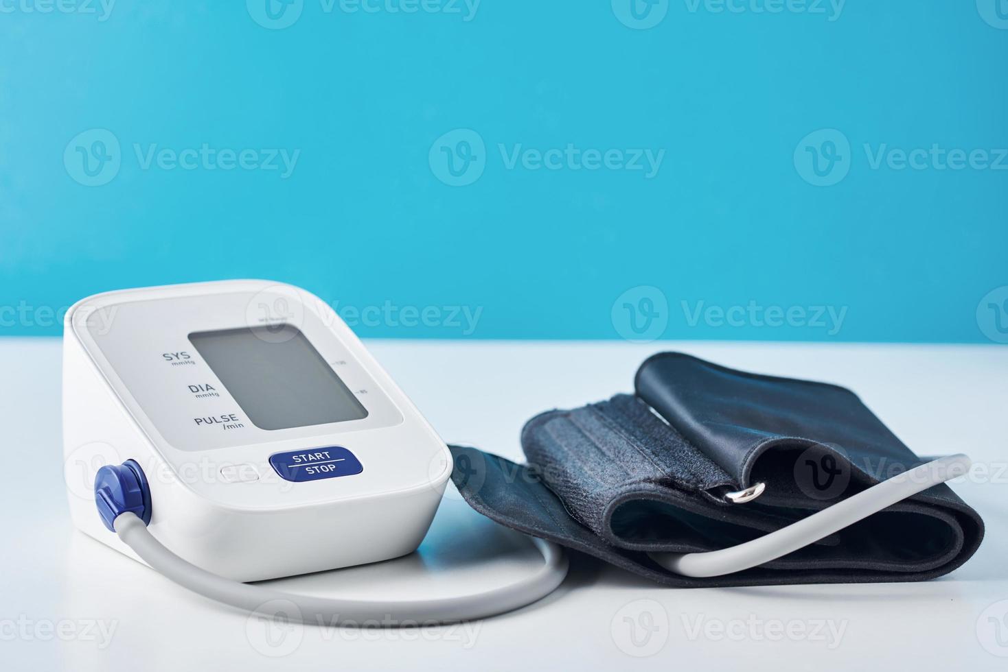 Digital blood pressure monitor on a blue background, closeup. Helathcare and medical concept photo