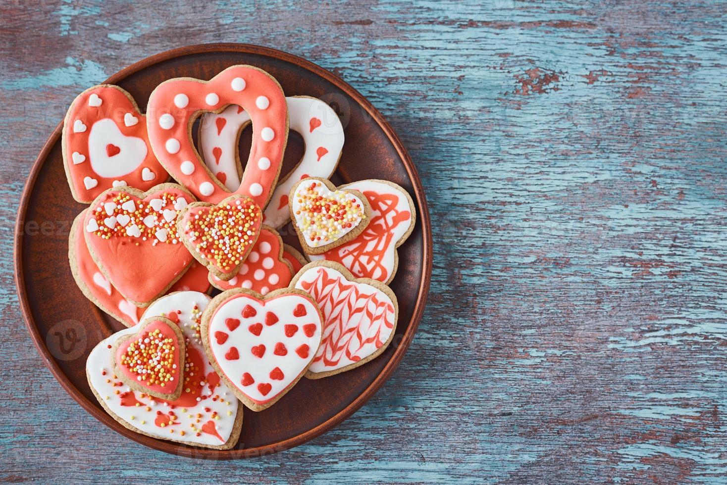 Decorated heart shape cookies in plate on the gray background. Valentines Day food concept photo