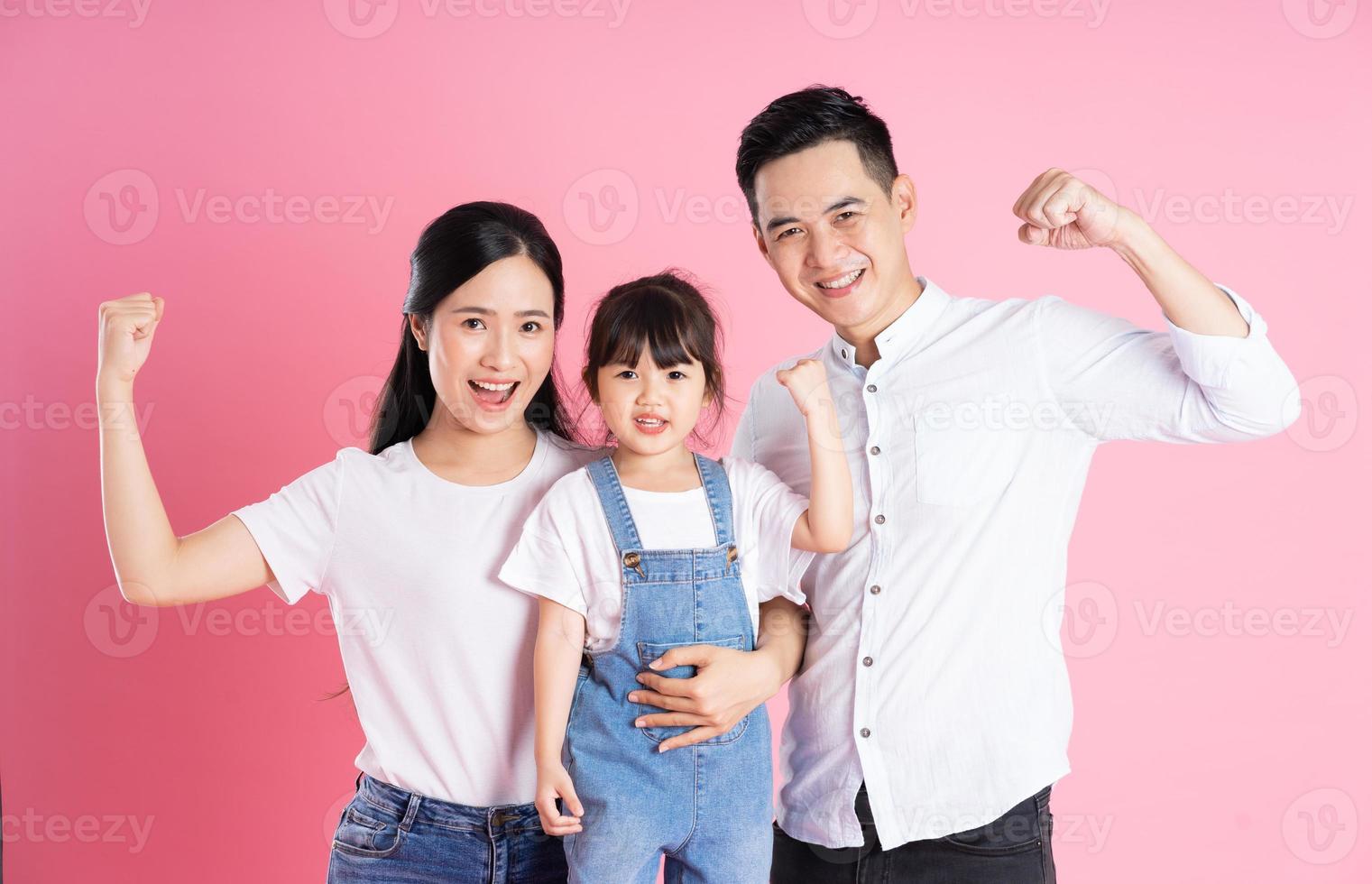 young asian family image isolated on pink background photo