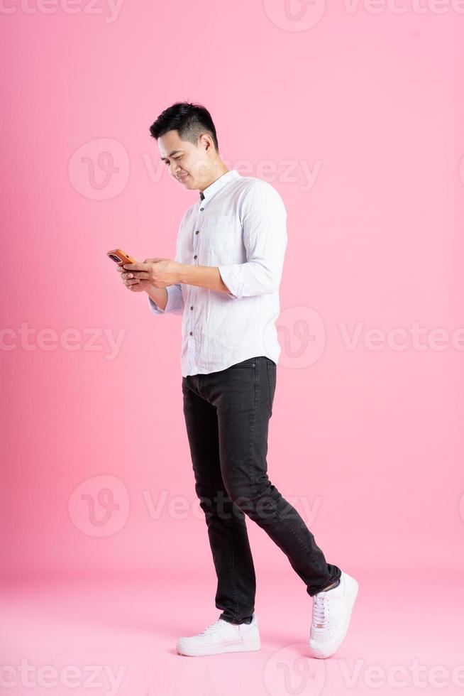 Asian man full body image, isolated on pink background photo