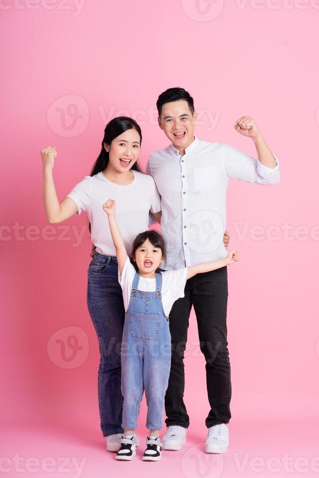 imagen feliz de la familia asiática joven, aislada en el fondo rosa foto