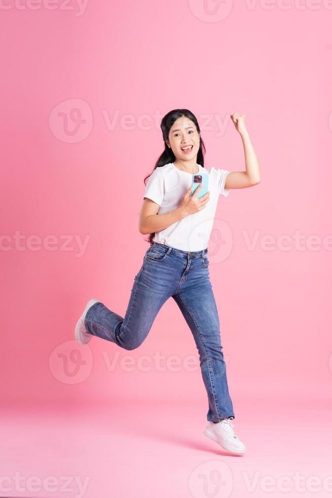 Full body image of Asian girl posing on pink background photo