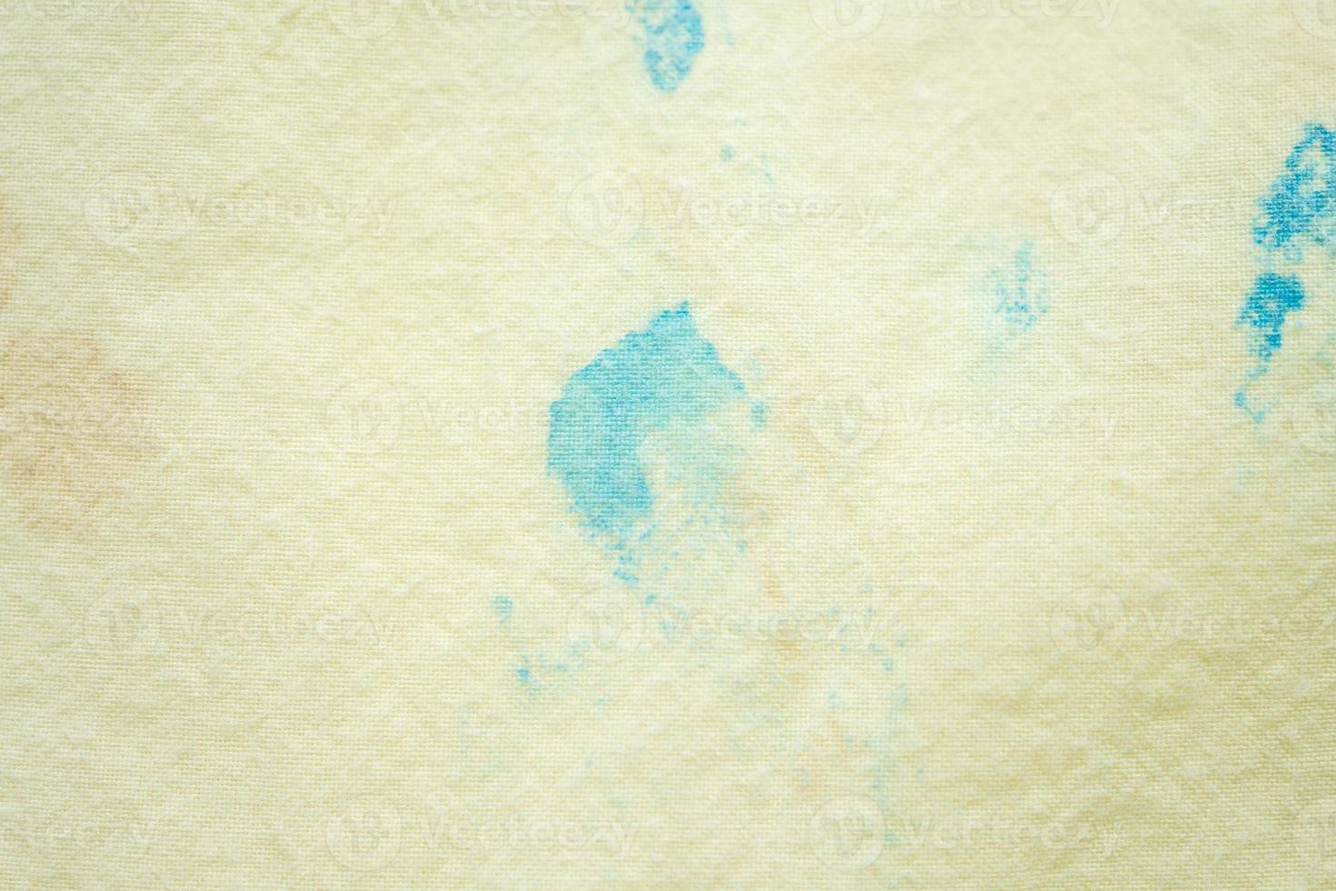 dirty color stain on yellow fabric texture background photo