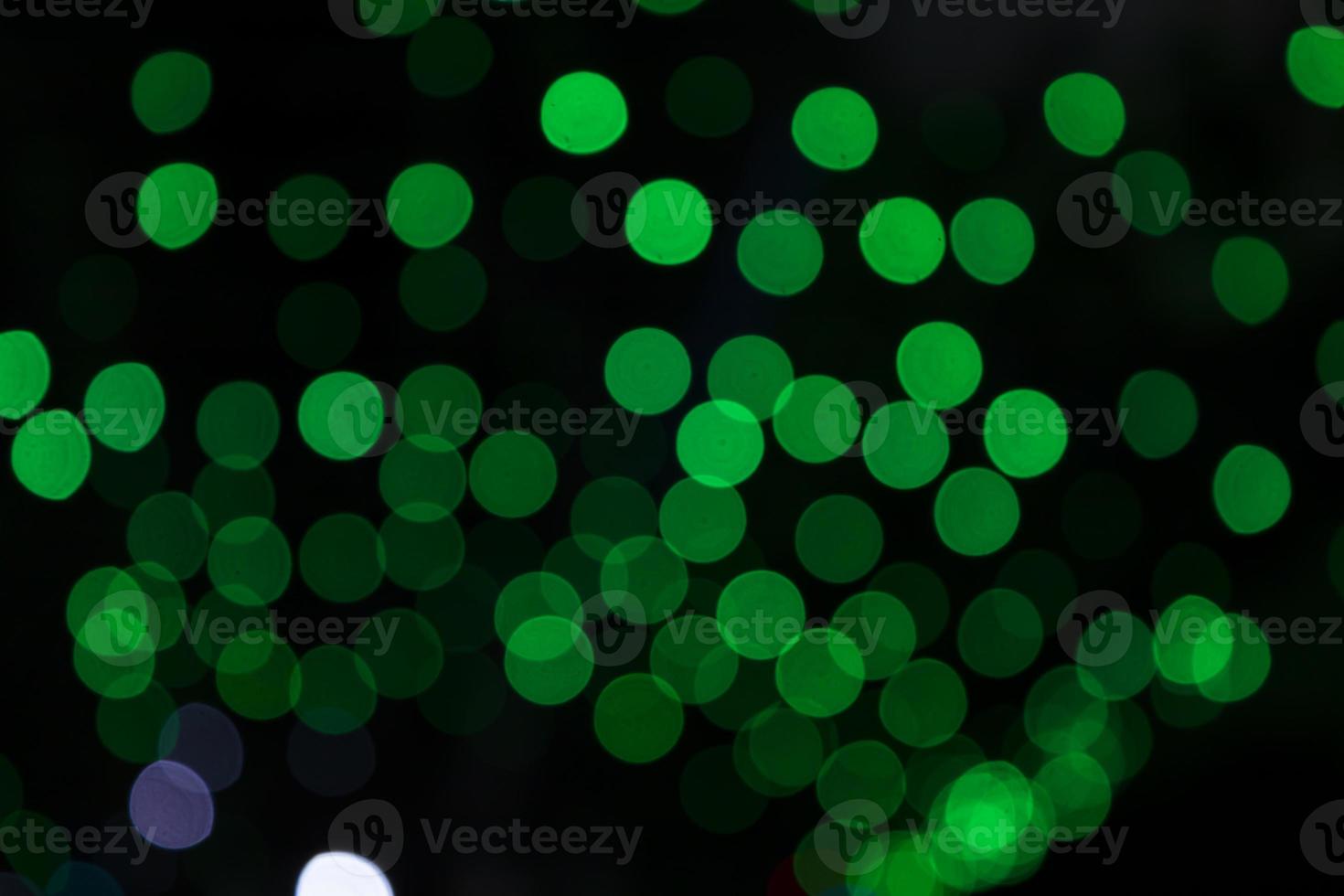 Green Defocus Abstract bokeh light effects on the night black background texture photo