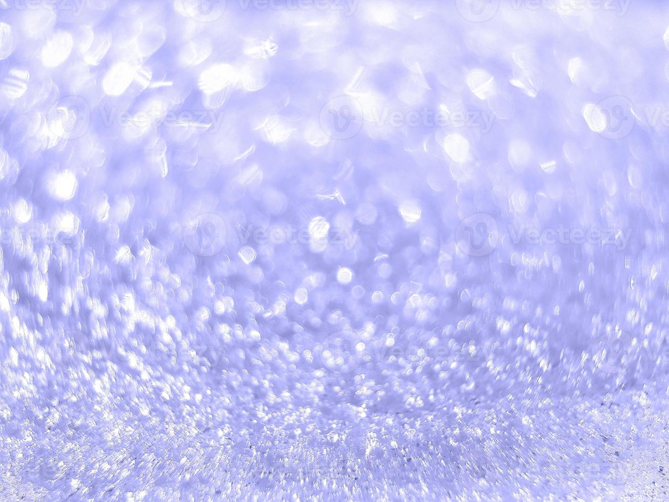 Inspired by trendy very peri color of the year 2022. Abstract blurred light violet sparkling bokeh. Shiny snow texture on a winter sunny day. Christmas and New Year background. Place for text. photo