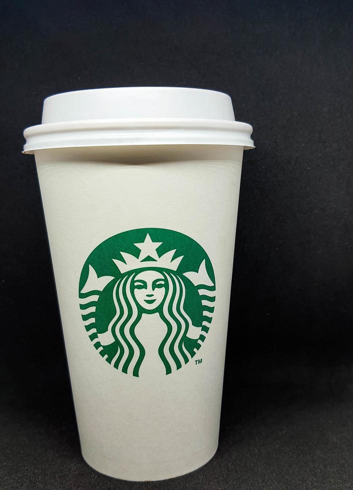 West Java, Indonesia in October 2022. A white paper cup with the starbuck logo, is used for hot drinks. photo