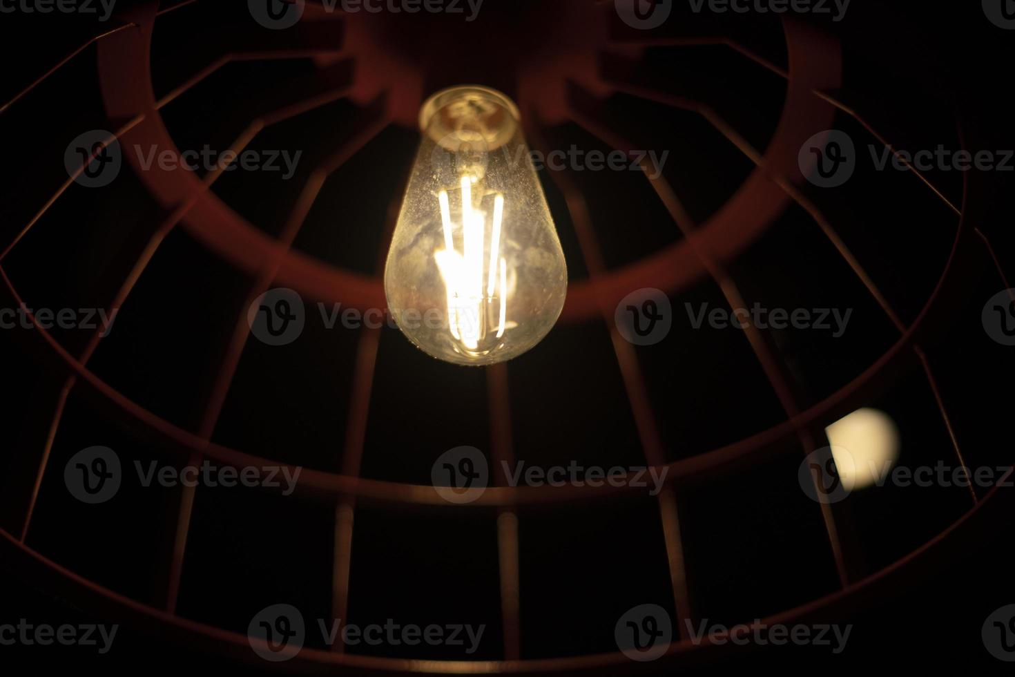 Lamp in dark. Incandescent lamp of round shape. photo