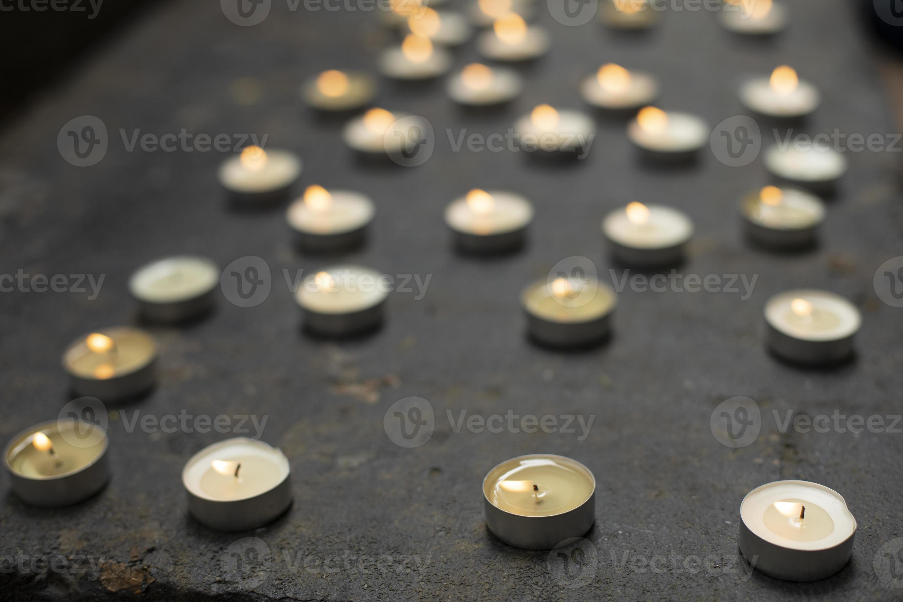 Lots of round candles on grave. Details of memorial ceremony. Candles