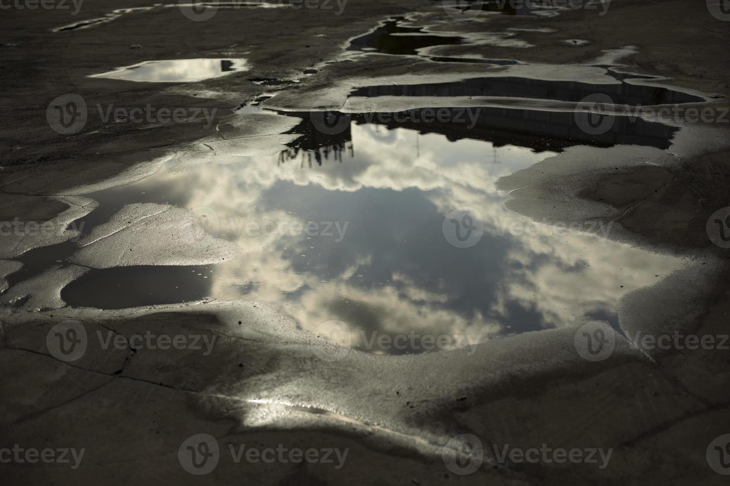 Large puddle on asphalt. Puddle after rain. Precipitation in city. photo