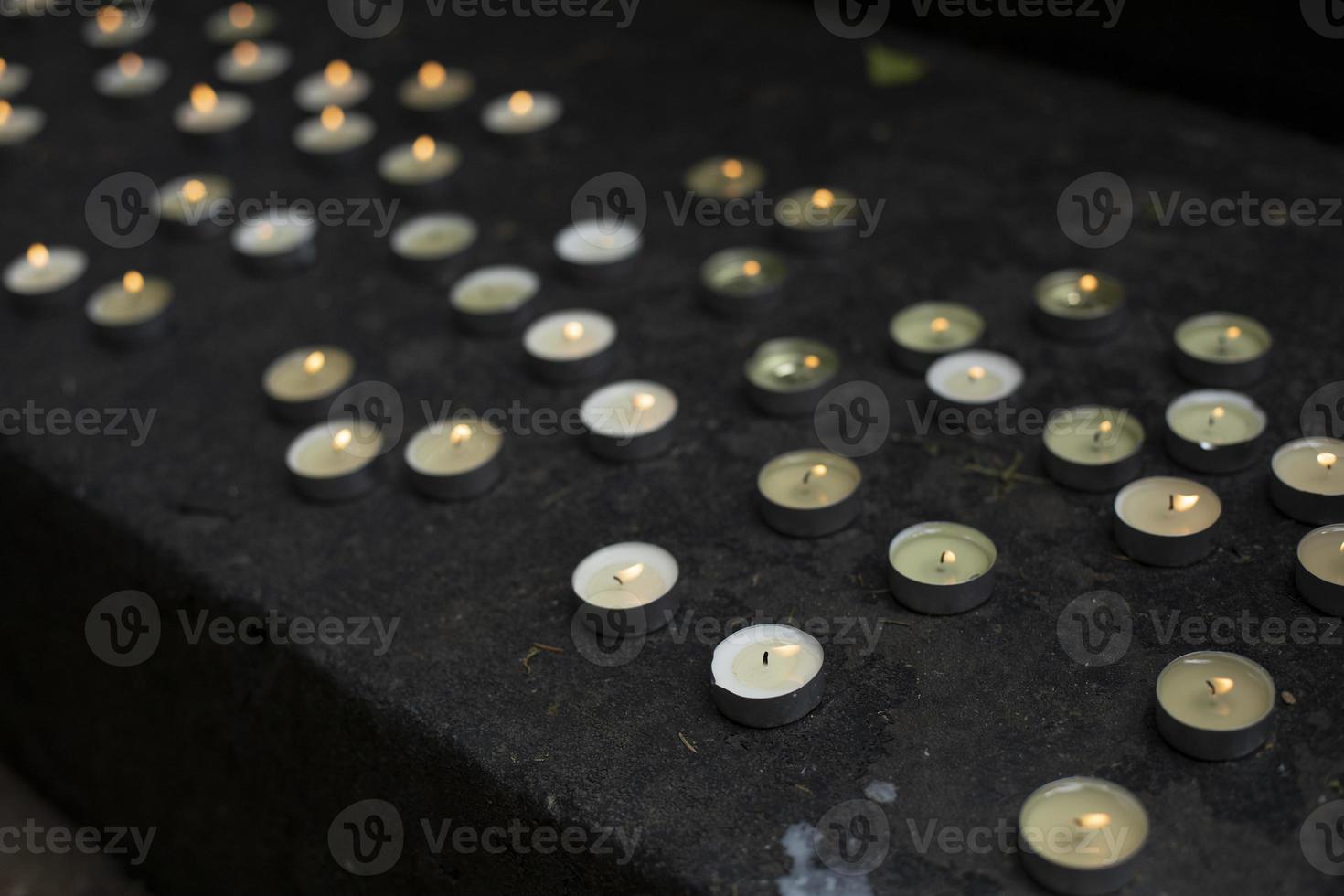 Lots of round candles on grave. Details of memorial ceremony. Candles