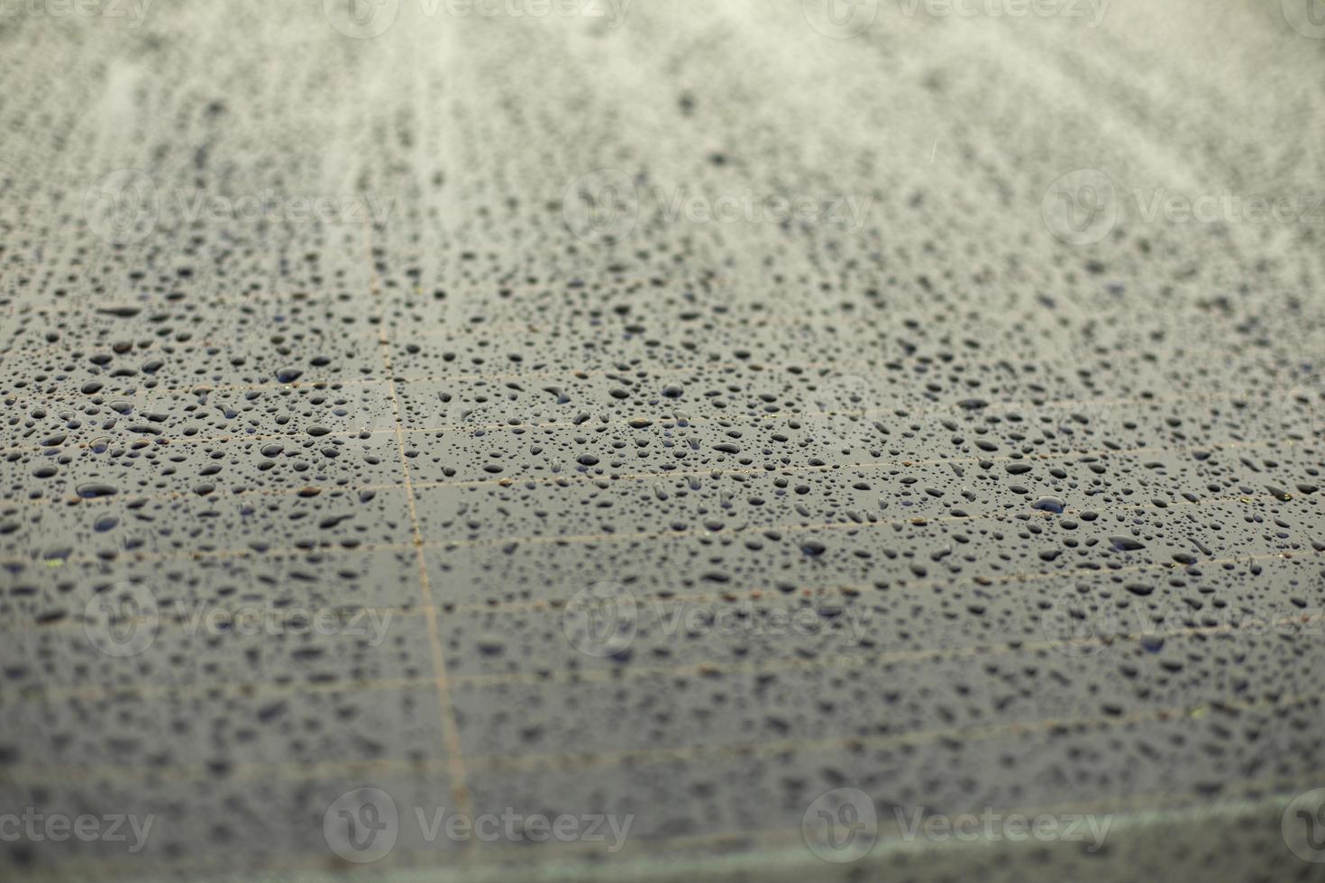 Drops of water on black surface. Car parts in rain. photo