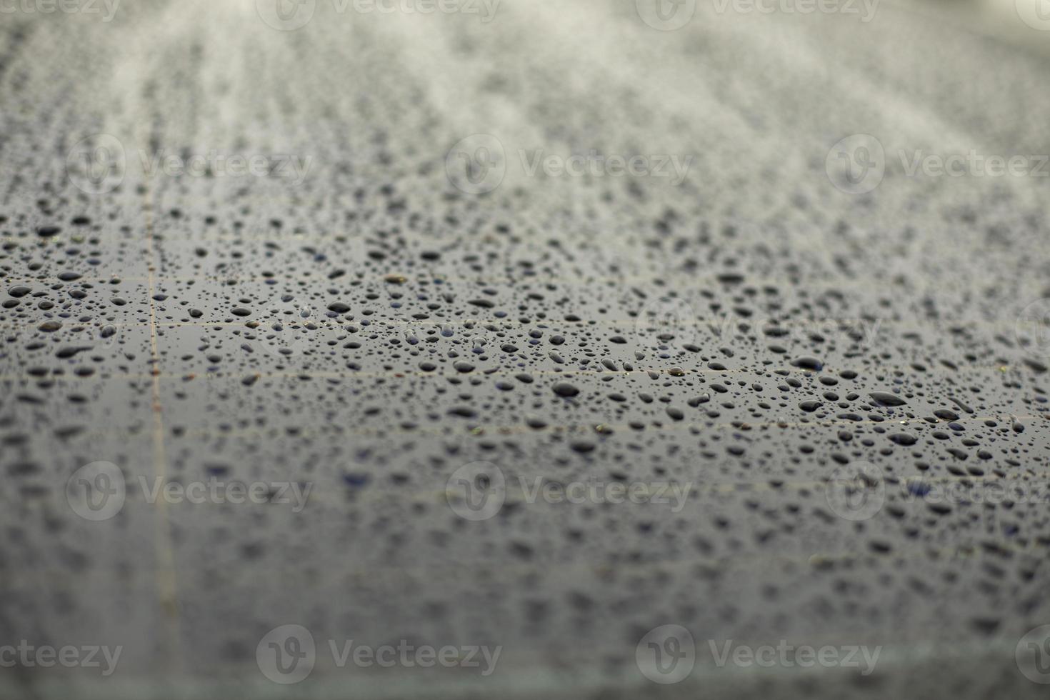 Drops of water on black surface. Car parts in rain. photo