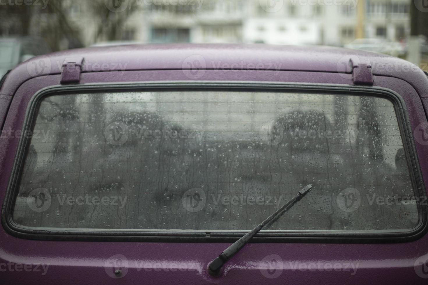 Car window is lighter in rain. Wet car in parking lot. Details of old transport. photo