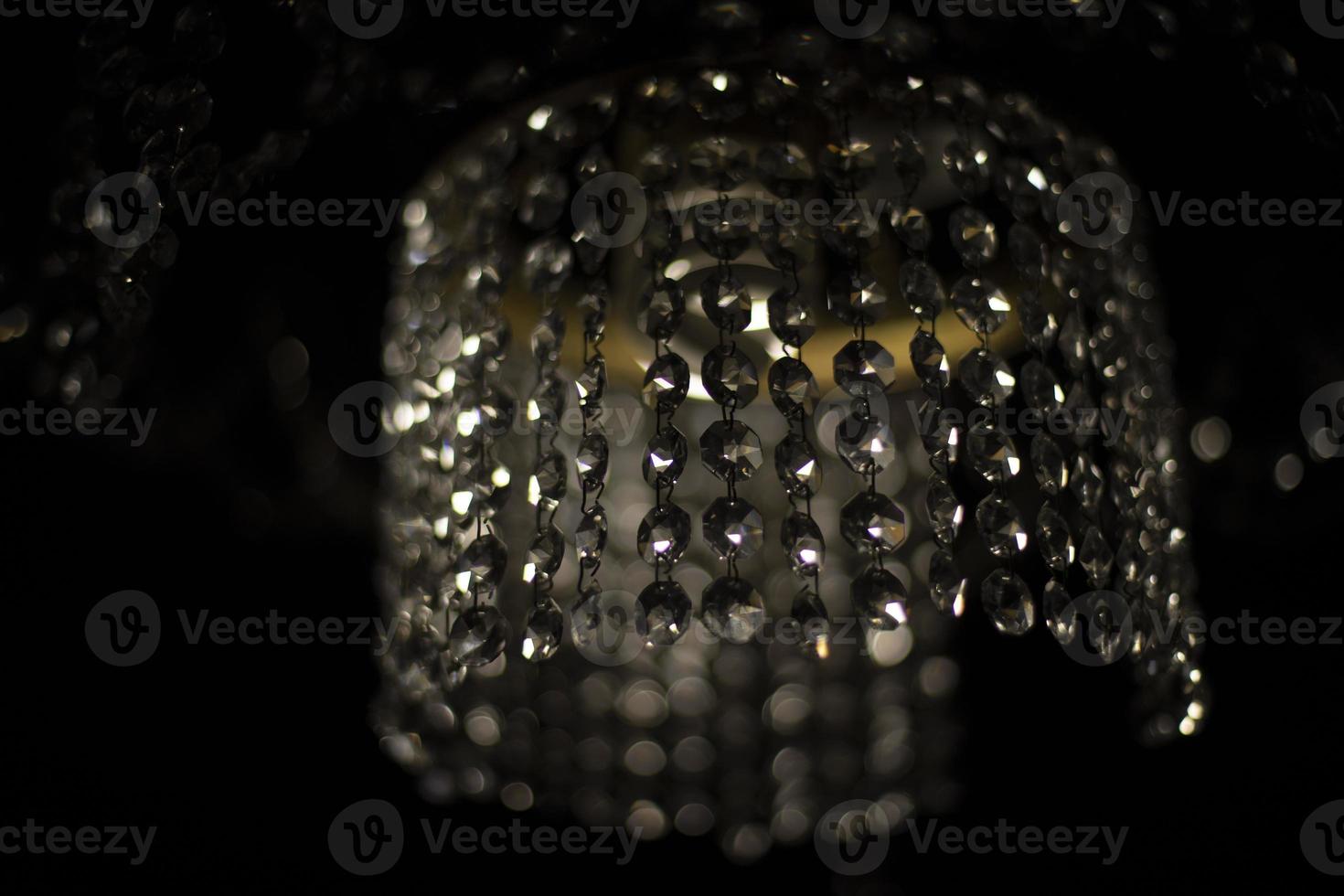 Glass chandelier in dark. Crystal and light. Interior details. Light in room. photo