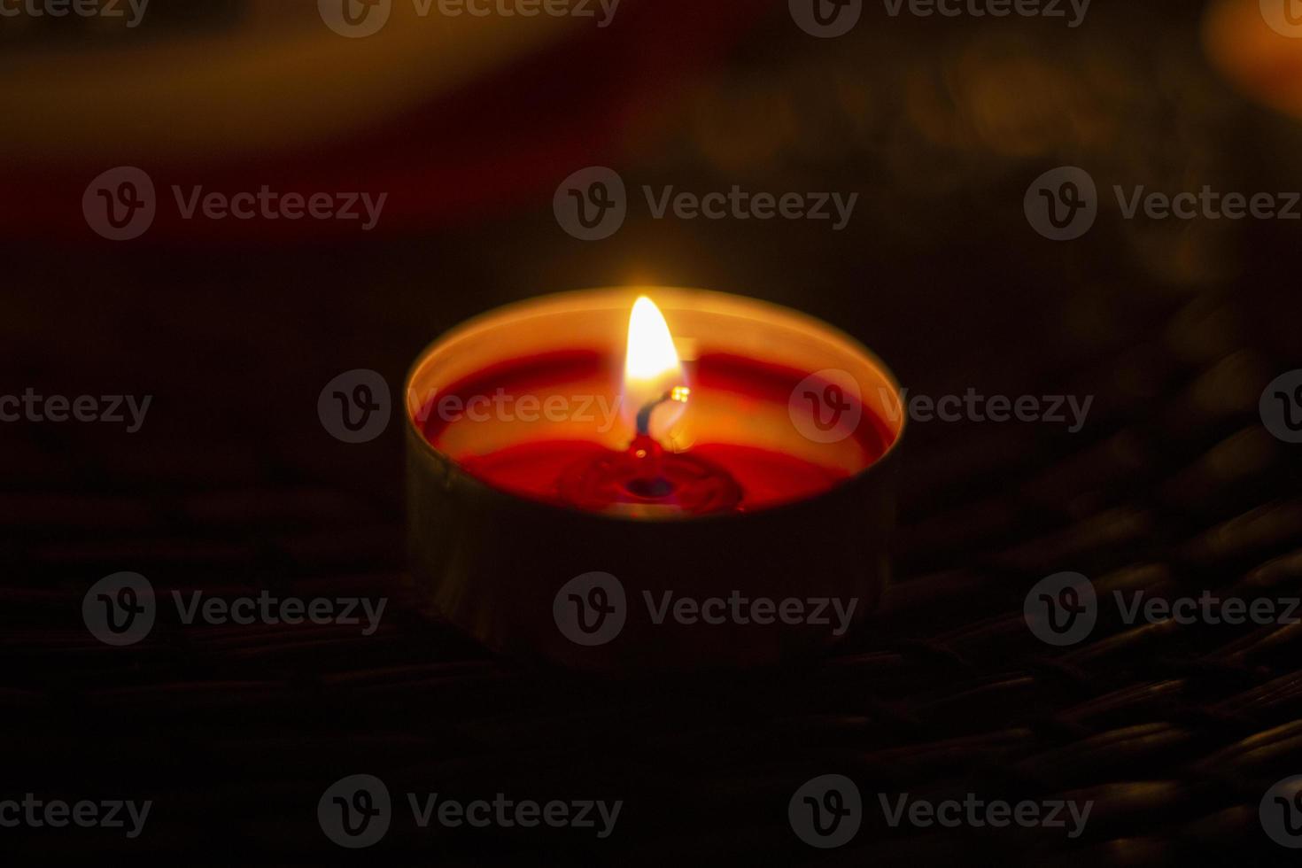 One candle in the dark. Round candle with a bright flame. photo