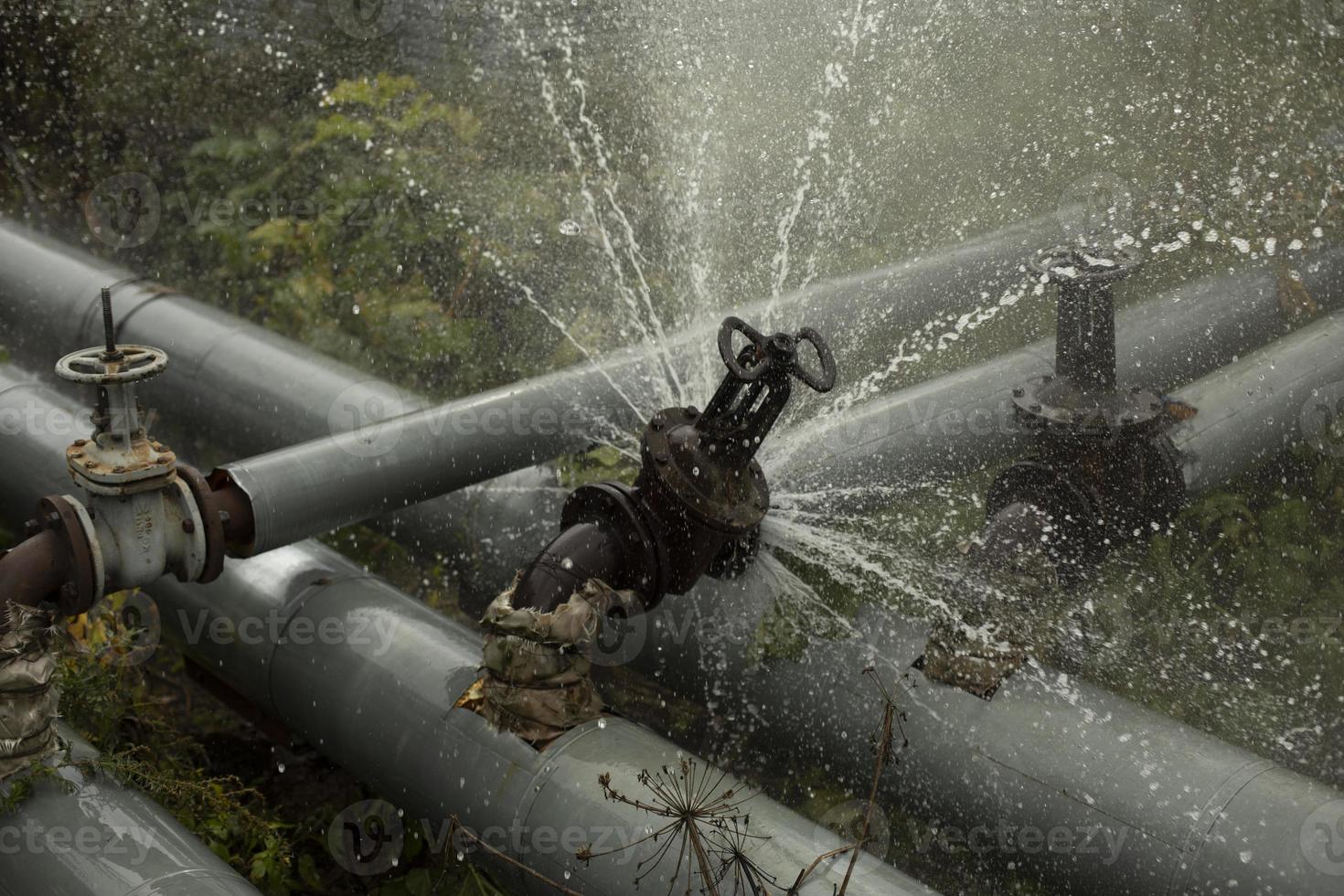Pipeline accident. Boiling water pours from pipe. Boiler room emergency. photo