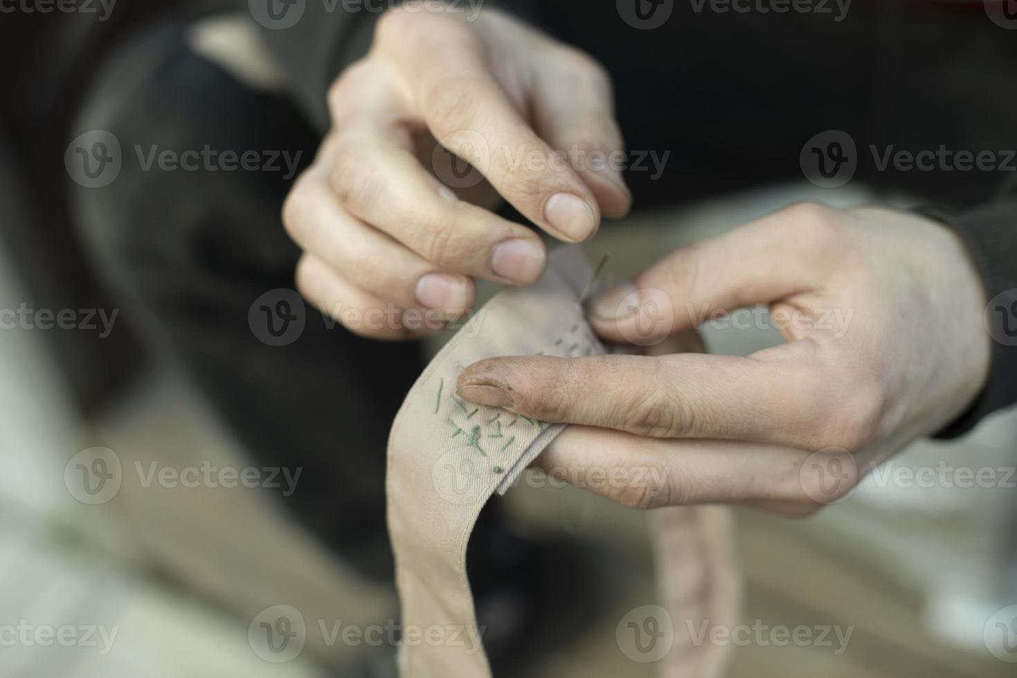 cinta de coser costura del cuello en el ejército. trabajo de tejedor. foto