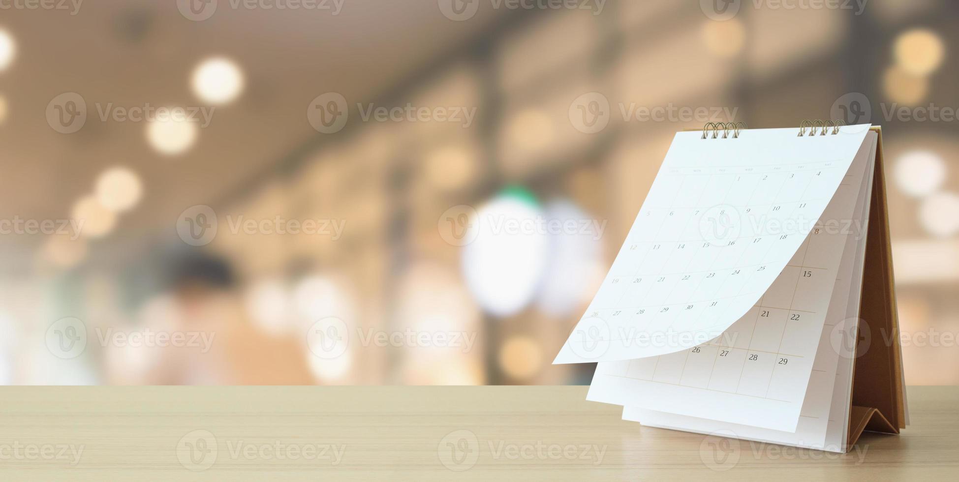 desk calendar on table with blurred bokeh background appointment and business meeting concept photo