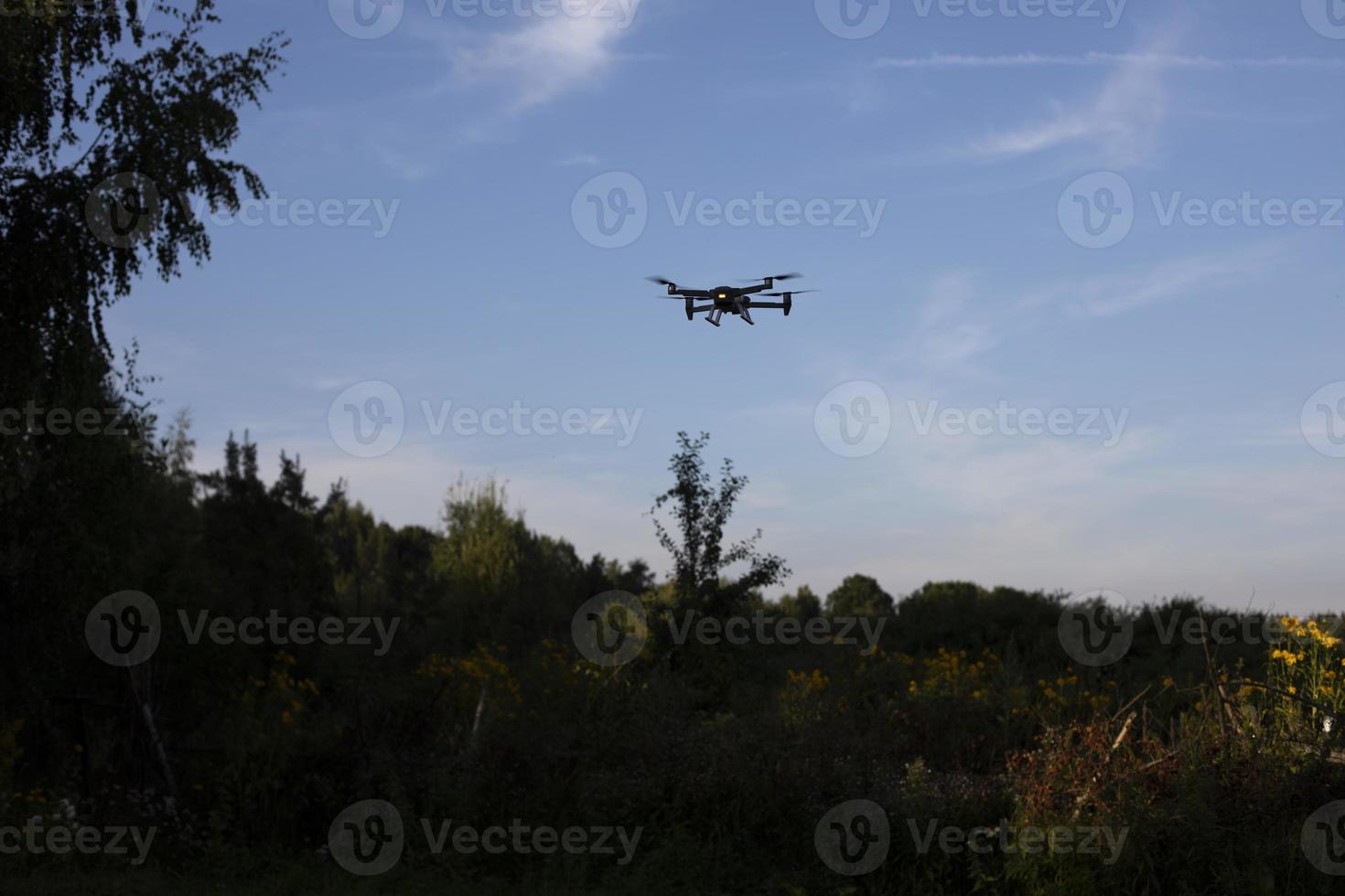 Drone in sky. Drone flight over forest. Air vehicle. photo