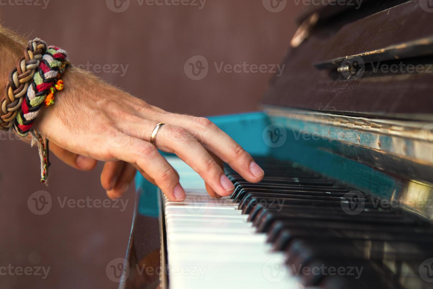 The hands of a young man playing piano on a street of city. photo