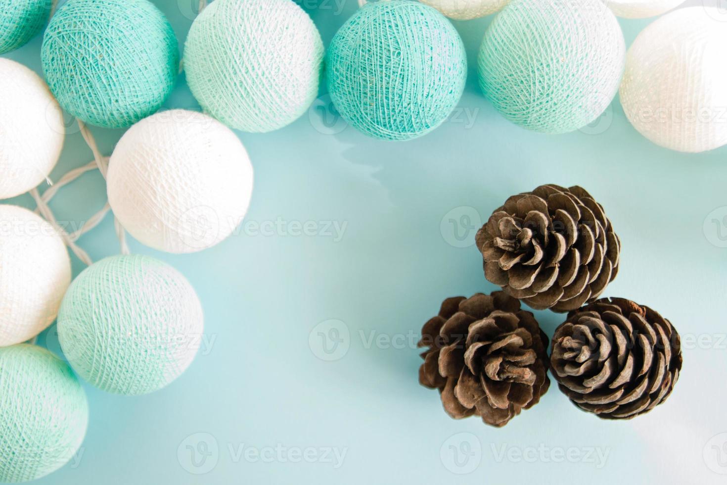 Three cones on the blue background with blue and white lights made of yarn threads, top view. Christmas decorations. photo