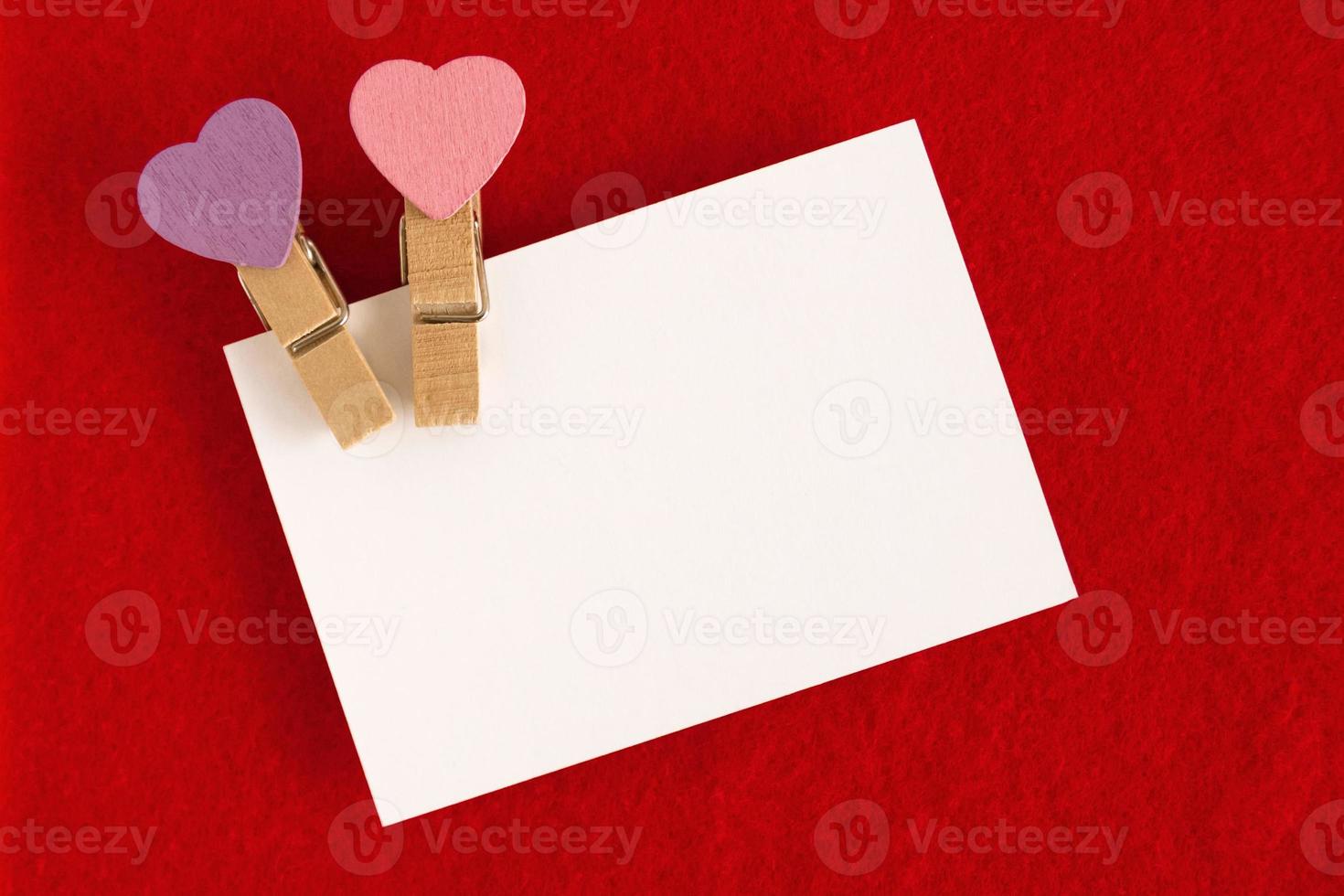 White sheet with pink and purple pins on the red background for Valentine Day. Copy space. photo