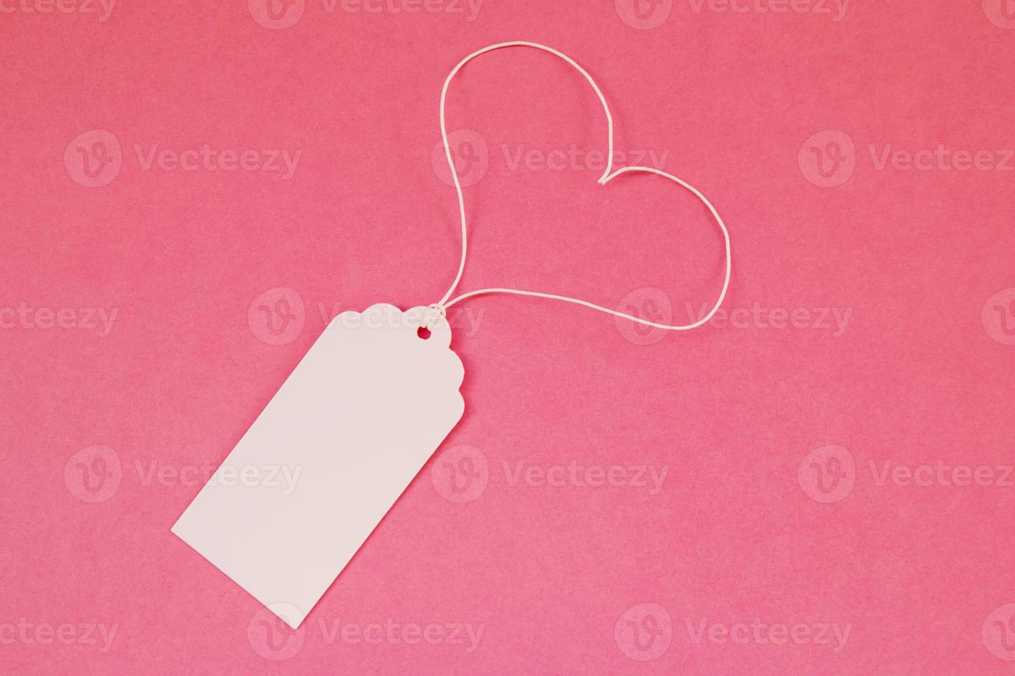 White blank paper price tag or label on the pink background, top view. photo