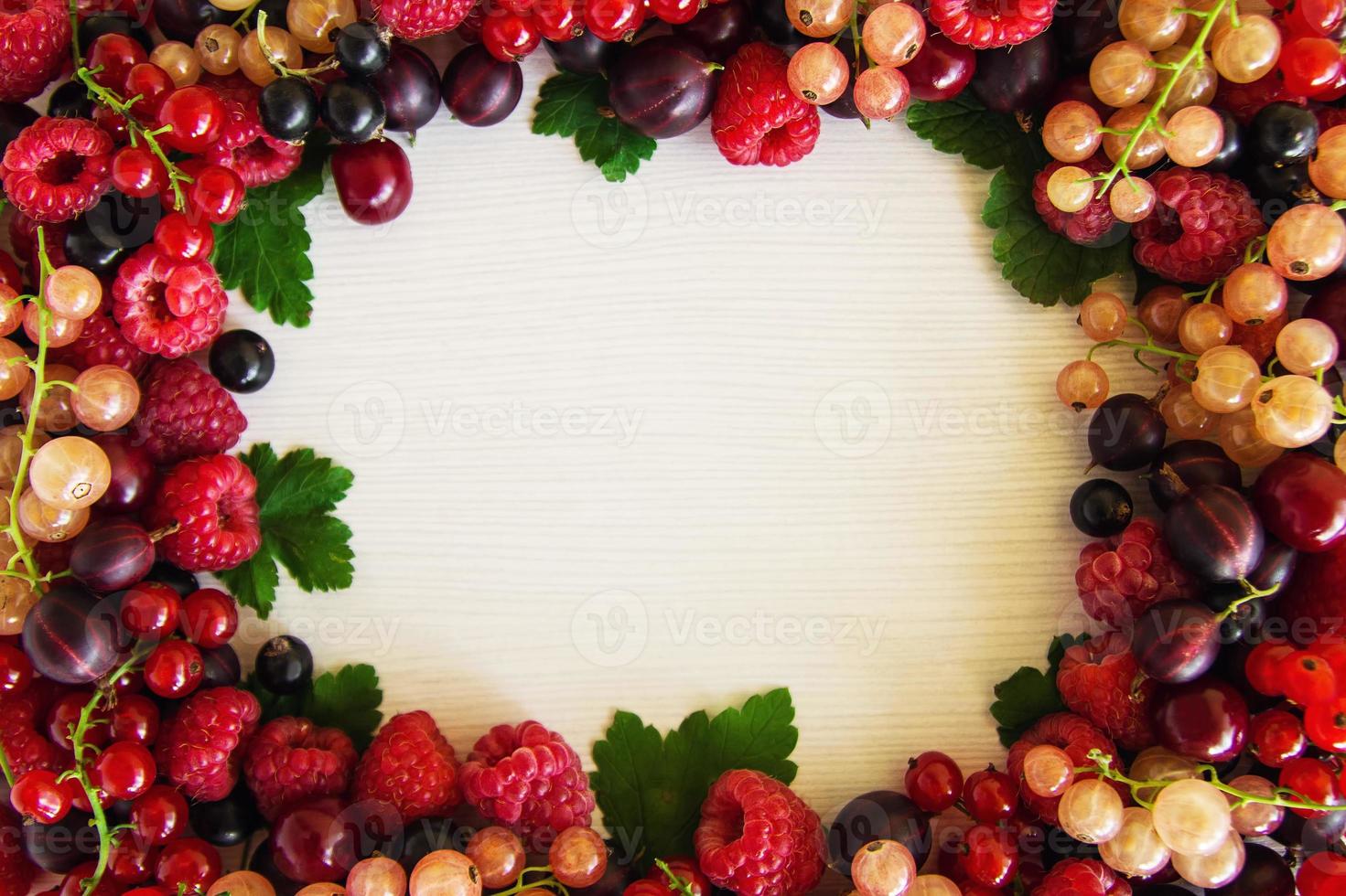 Frame from mixed summer berries on the white wooden background, top view. photo
