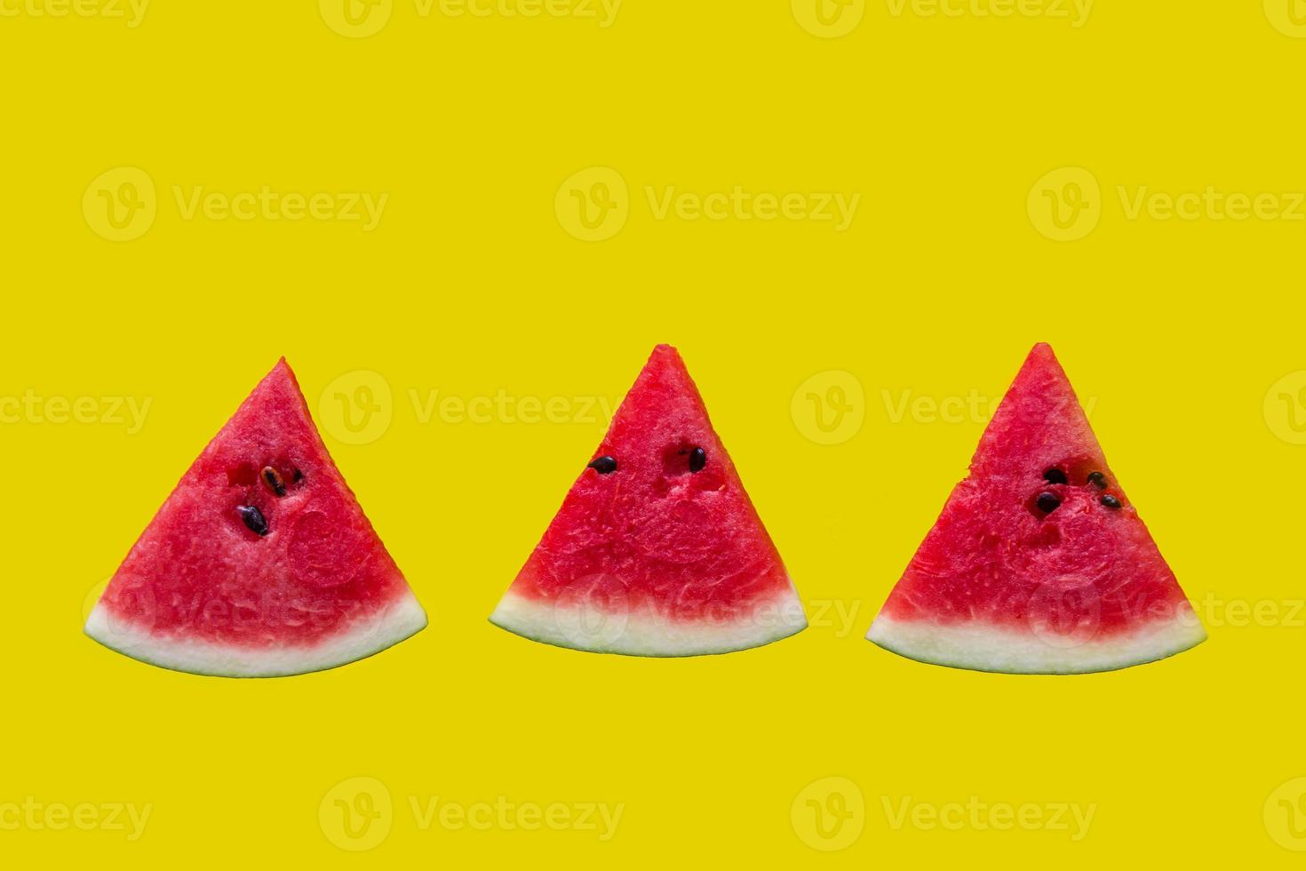 Three slices of red watermelon on yellow background. photo