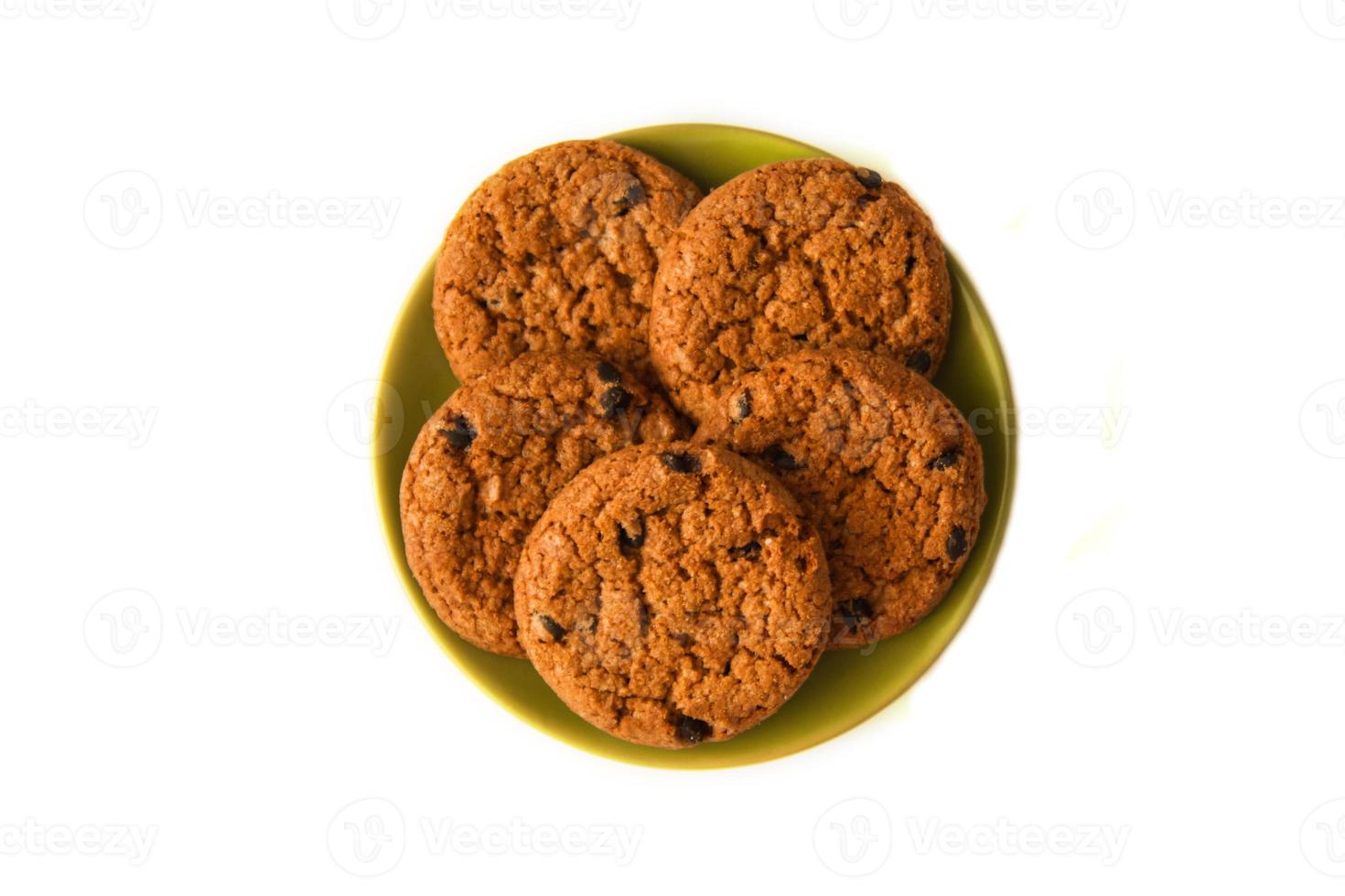 Oatmeal cookies with chocolate on the saucer on the white background. photo