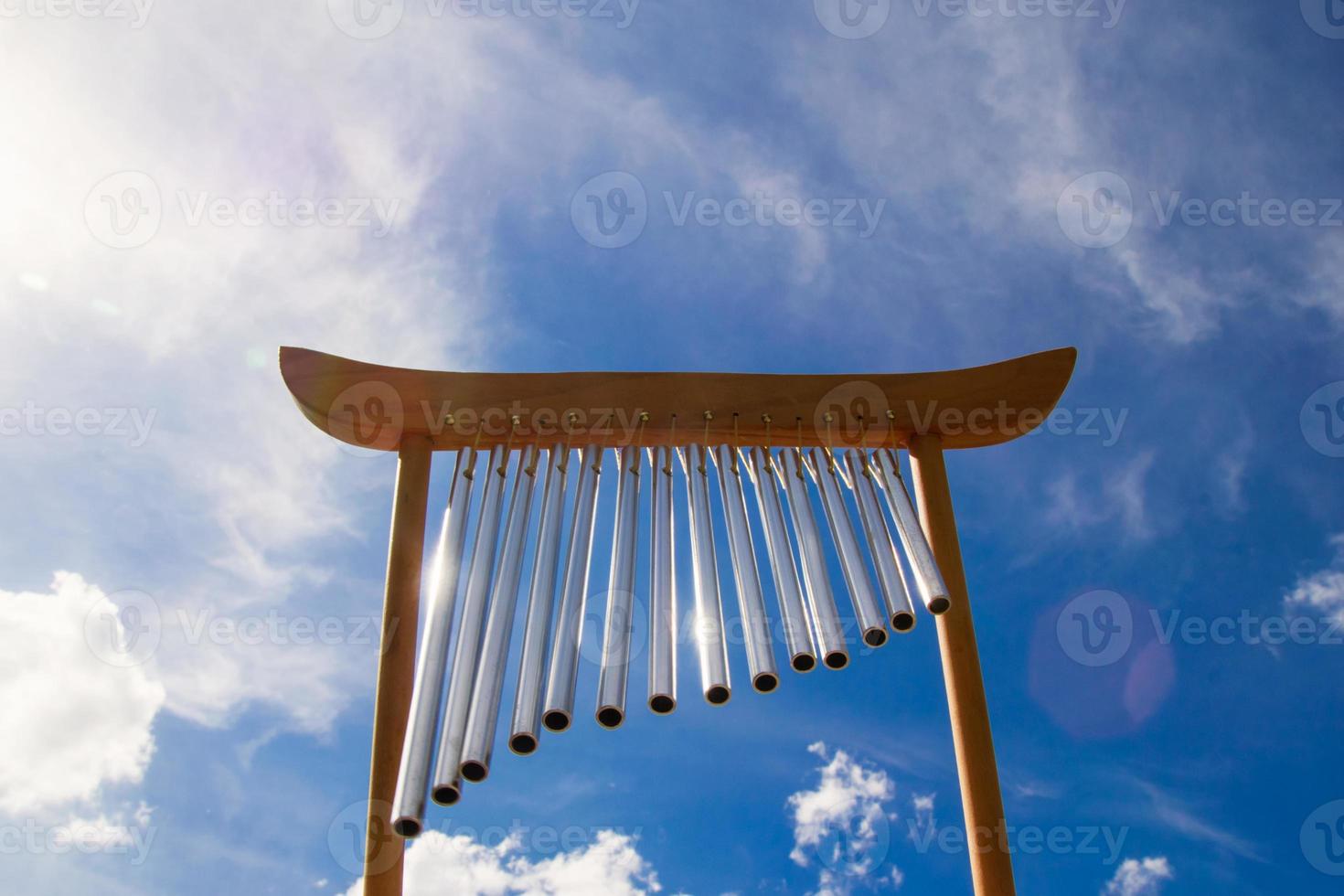 Wind musical chimes on the background of blue cloudy summer sky
