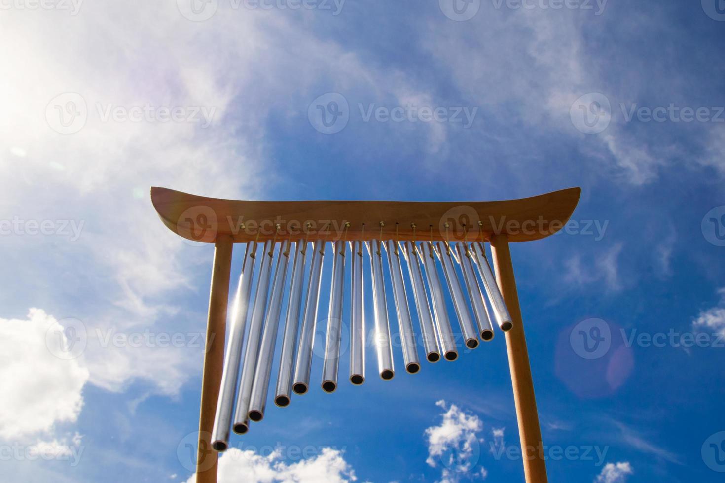 Wind musical chimes on the background of blue cloudy summer sky. photo