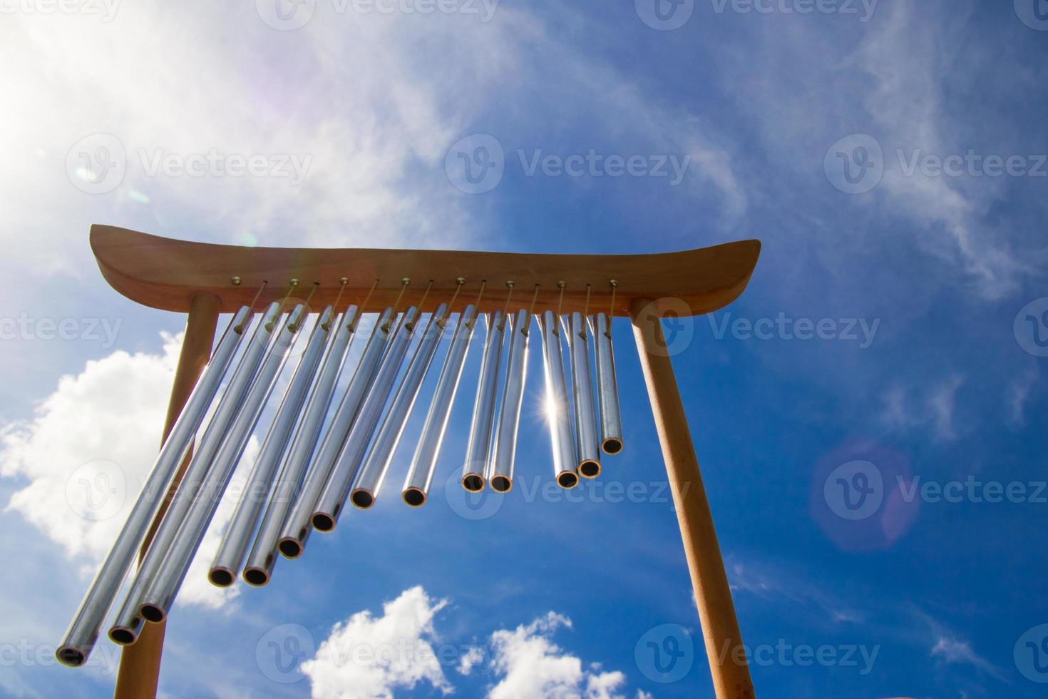 Wind musical chimes on the background of blue cloudy summer sky. photo