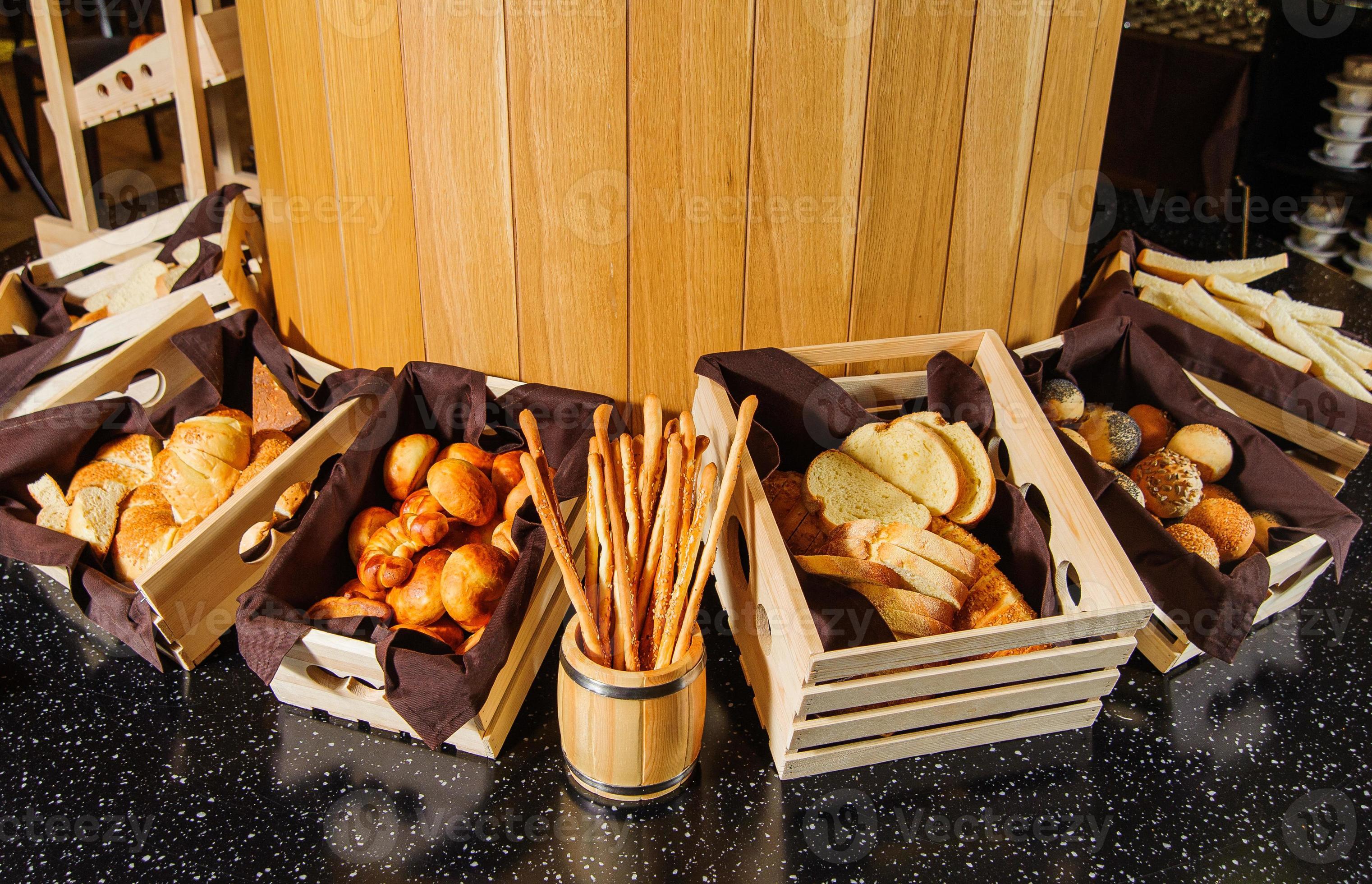 A buffet table with variety of bread in the wooden baskets 13060112