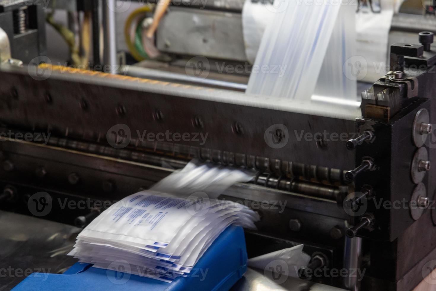 un primer plano de una máquina que imprime etiquetas de jeringas en un almacén de producción médica foto