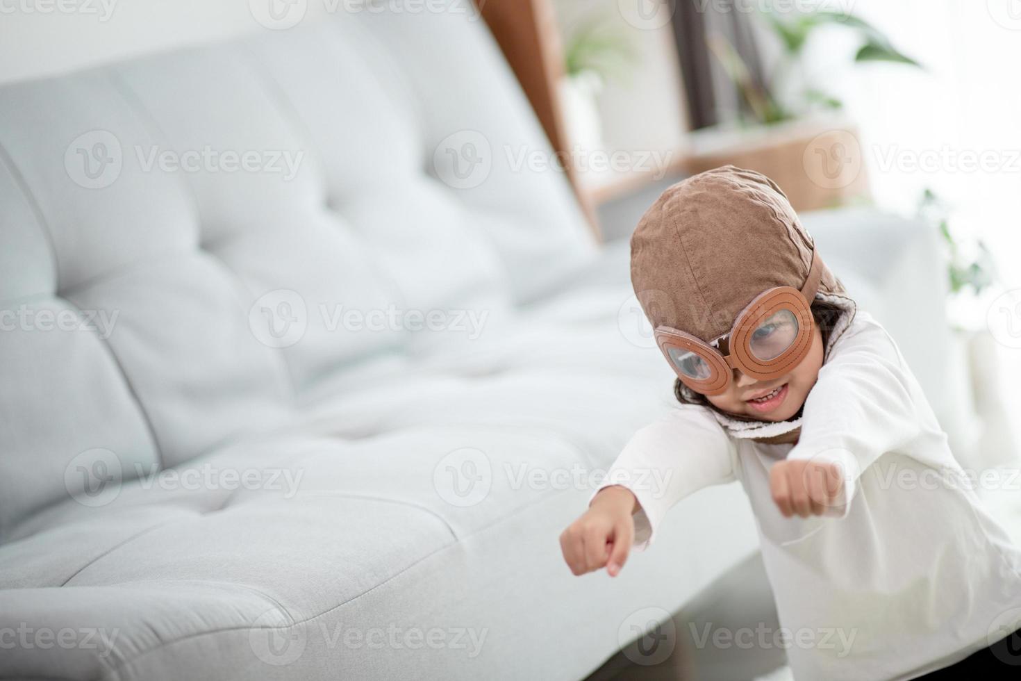 A cute little girl dressed in a cap and glasses of a pilot. The child dreams of becoming a pilot. photo