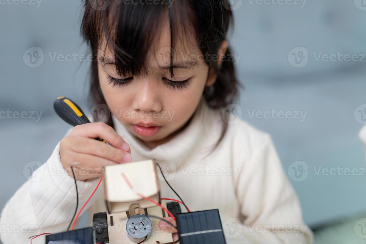 Inventive kid constructing robot cars at home photo