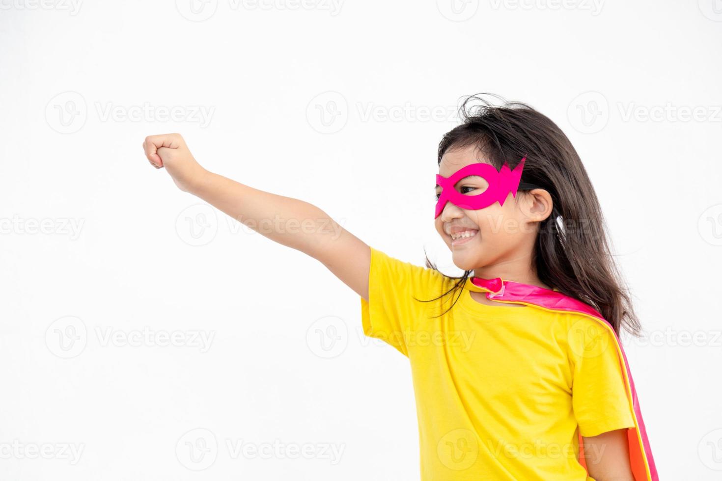 Funny little girl playing power super hero over white background. Superhero concept. photo